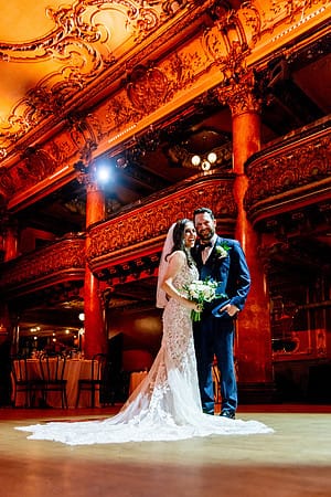 Romantic couple portrait under stage lighting inside the Great American Music Hall.