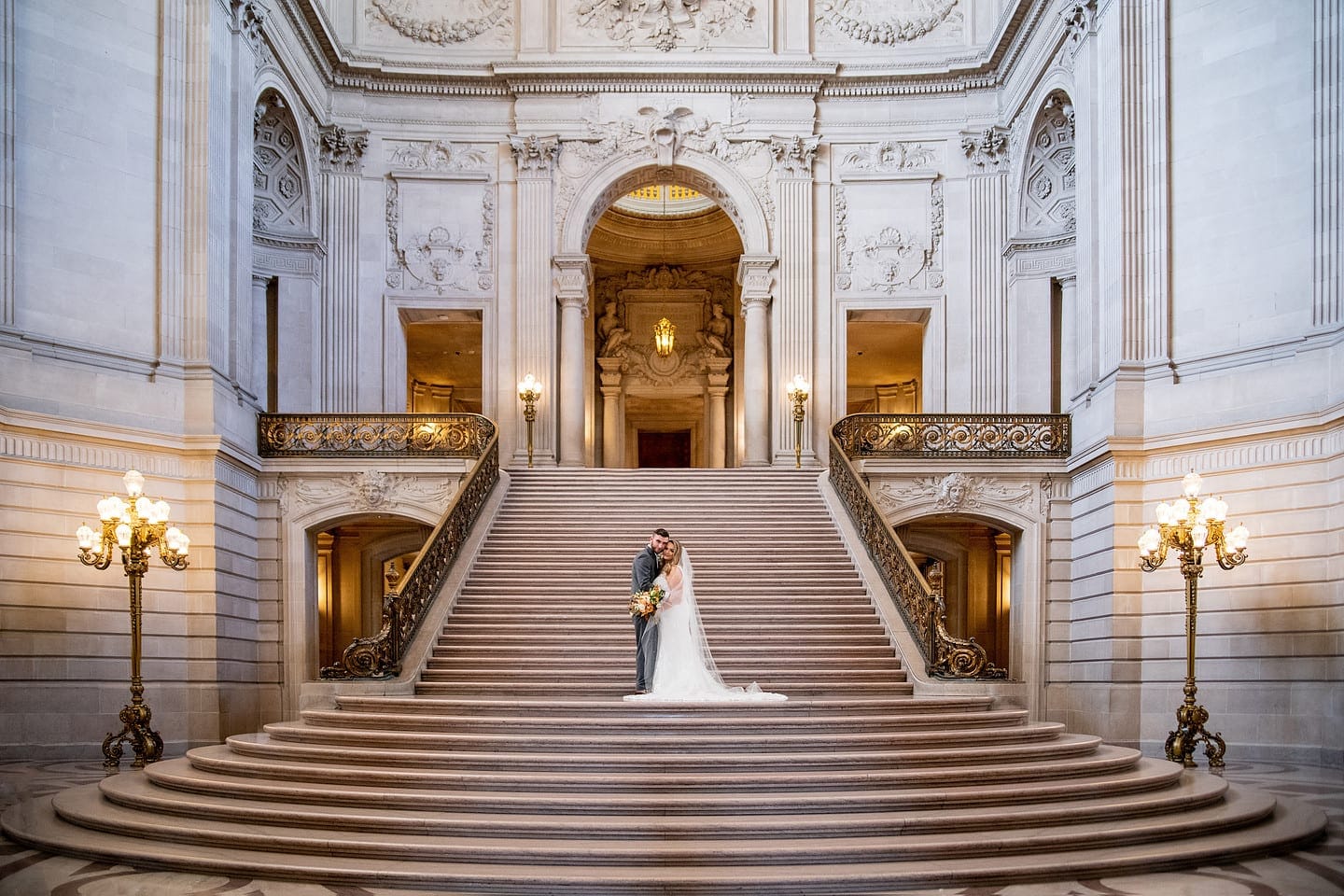 Bride and groom portrait on the iconic grand staircase at San Francisco City Hall.
